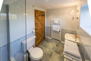 Bathroom with a bath and thermostatic shower above and a heated towel rail