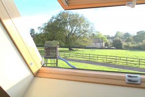 View through the window of the gardens at Oak Tree Cottage,.